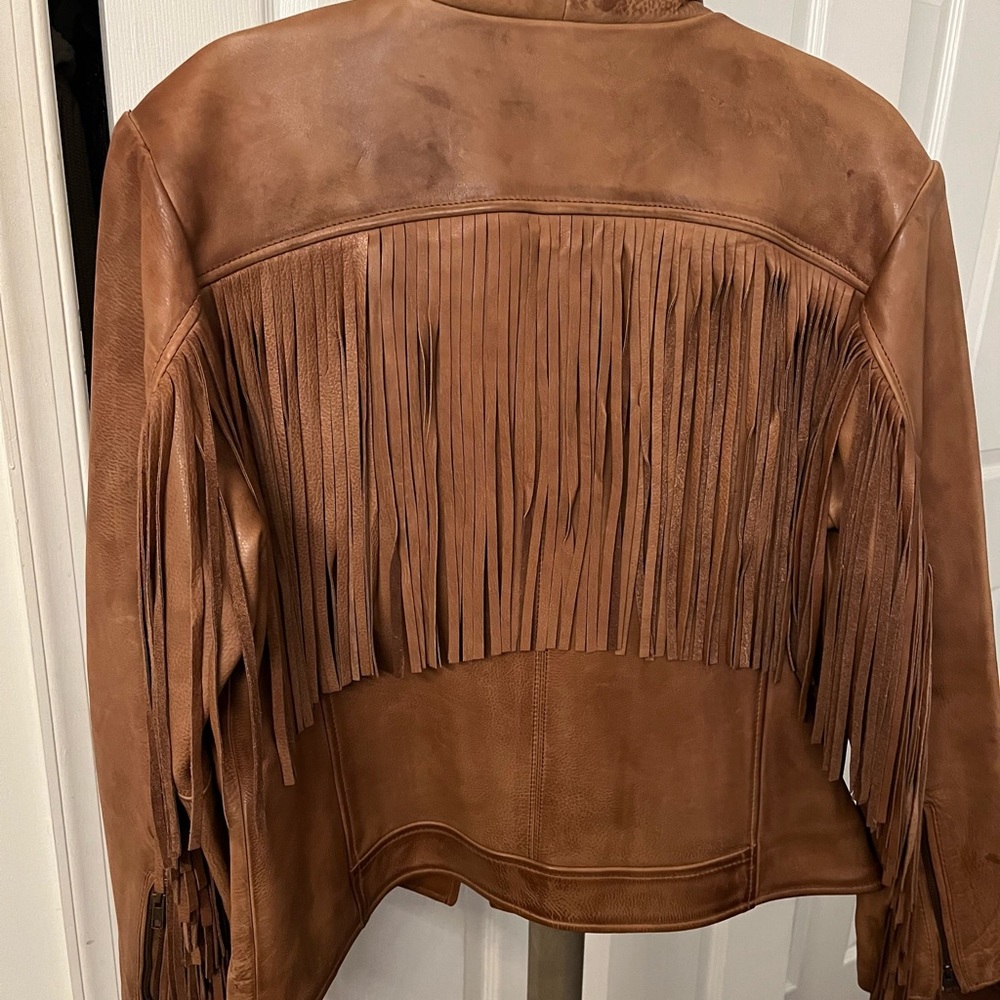 Women all leather fringe jacket on back and sleeves to the back.